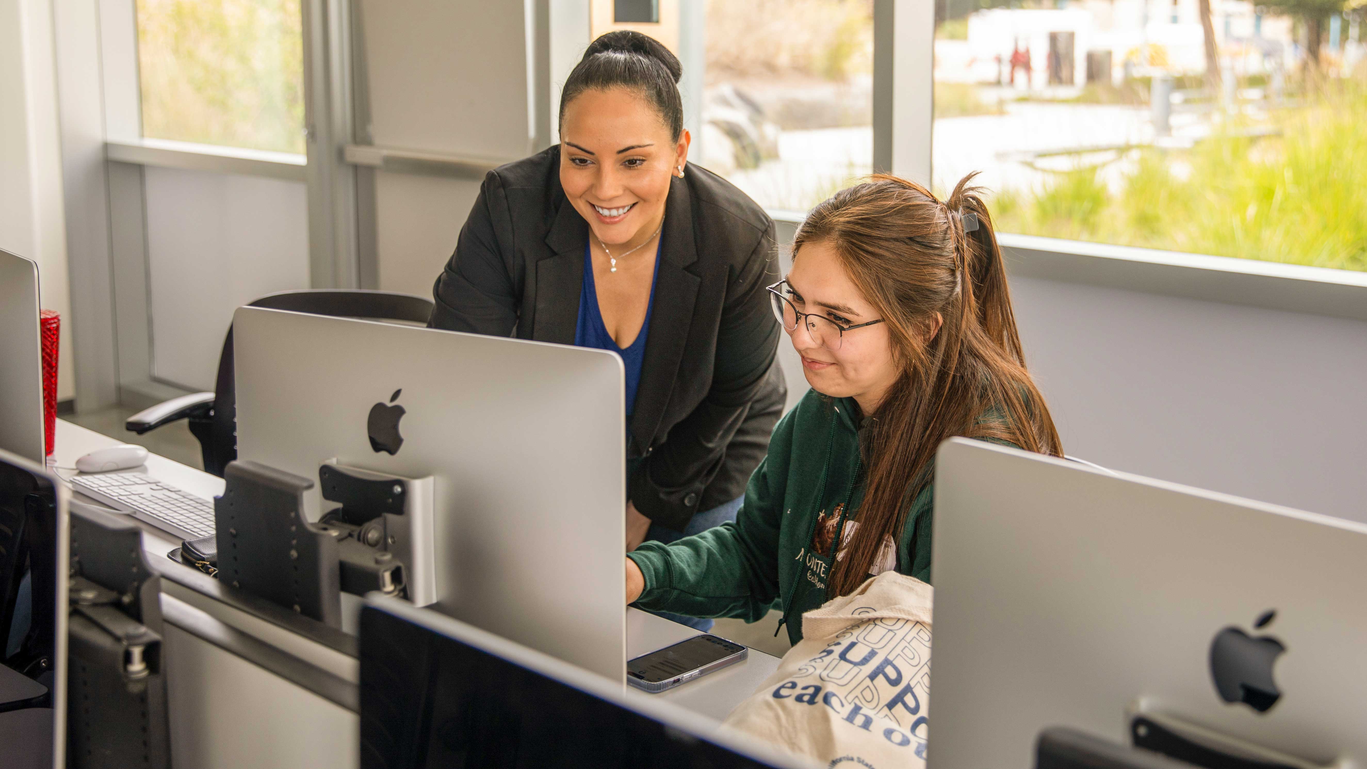 faculty and a student looking at a computer screen