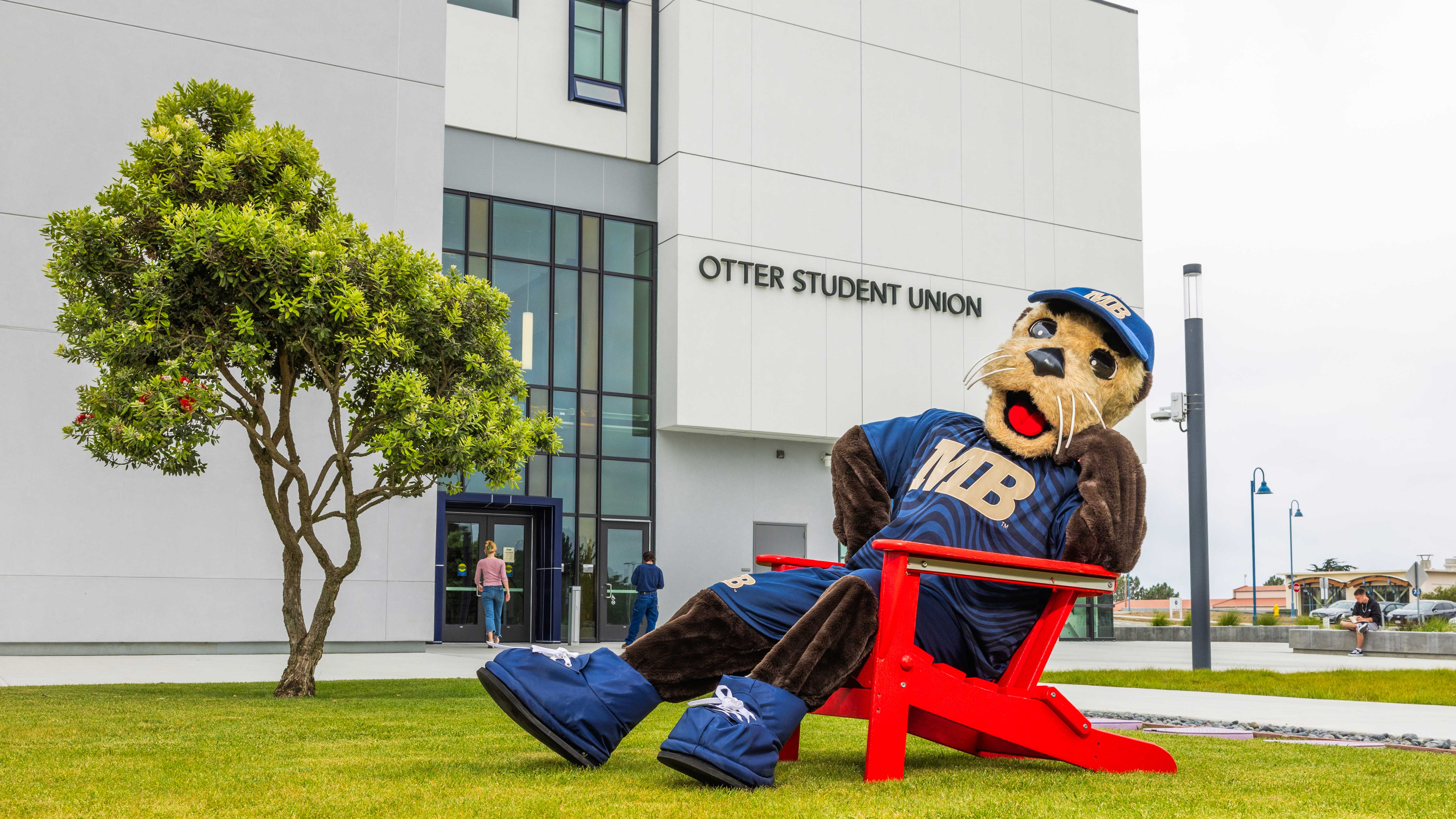mascot sitting in a Andirondack red chair outside