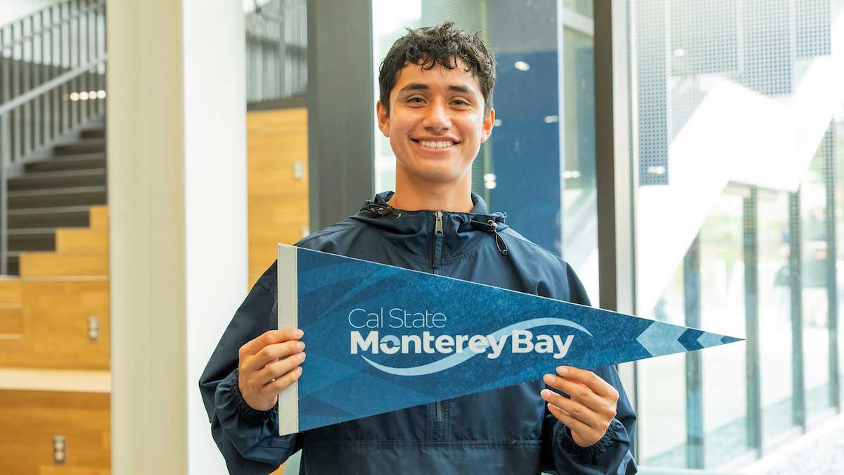 Student holding a CSU MB flag